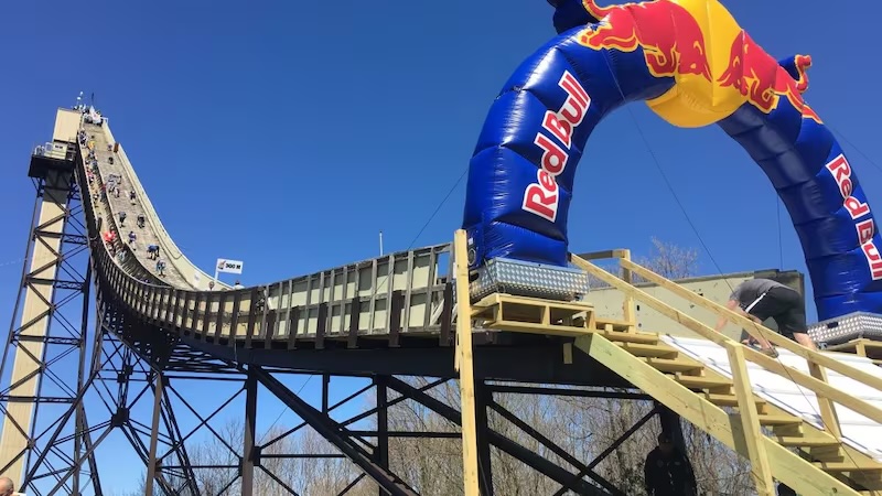 A ski jump with a Red Bull banner